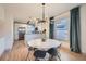 Dining area features modern lighting fixture with view to kitchen with stainless steel appliances at 2436 W 34Th Ave, Denver, CO 80211