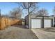 Two-car garage featuring white doors and a gravel driveway, set beside a wooden fence and under a blue sky at 2436 W 34Th Ave, Denver, CO 80211