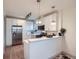 Modern kitchen with white cabinets, stainless steel appliances and breakfast bar counter at 2436 W 34Th Ave, Denver, CO 80211