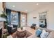 Comfortable living room features hardwood floors, brick fireplace, and view to bedroom through doorway at 2436 W 34Th Ave, Denver, CO 80211