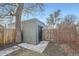 A quaint brick shed is nestled beside a wooden fence in a backyard with fresh concrete sidewalk in a residential neighborhood at 2436 W 34Th Ave, Denver, CO 80211