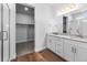 This well-lit bathroom has double sinks, granite countertops and an attached walk-in closet at 2143 Peralta Loop, Castle Rock, CO 80104