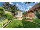 Well-maintained backyard with lush green lawn, garden shed, colorful flowers, and mature trees, offering privacy at 11224 W 28Th Pl, Lakewood, CO 80215