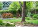 Lush backyard garden featuring a vibrant mix of plants and landscaping around a mature tree and a small chimenea at 11224 W 28Th Pl, Lakewood, CO 80215