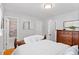 Neutral bedroom showcasing hardwood floors, a wooden dresser, and a peek into the renovated bathroom at 11224 W 28Th Pl, Lakewood, CO 80215
