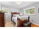 Cozy bedroom featuring a wooden bed frame, plush pillows, and natural light from the large windows at 11224 W 28Th Pl, Lakewood, CO 80215