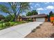 Charming single-story home with a well-manicured lawn, mature tree, and an extended driveway leading to a two-car garage at 11224 W 28Th Pl, Lakewood, CO 80215