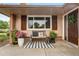 Charming front porch with a striped rug, seating, potted plants, and a decorative pillow, creating a welcoming entrance at 11224 W 28Th Pl, Lakewood, CO 80215