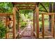 Charming garden walkway framed by a wooden pergola with lush greenery and potted plants, creating a serene outdoor space at 11224 W 28Th Pl, Lakewood, CO 80215