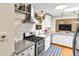 Well-appointed kitchen features modern appliances, white cabinetry, and a stylish range hood for a sleek, contemporary look at 11224 W 28Th Pl, Lakewood, CO 80215