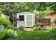 Storage shed in a landscaped garden, surrounded by colorful flowers and lush greenery at 11224 W 28Th Pl, Lakewood, CO 80215