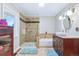 Bathroom with tile shower, soaking tub, and updated vanity at 4716 Broadway, Denver, CO 80216
