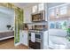 Modern kitchen with stainless steel appliances and white cabinets in a charming home with hardwood floors and open layout at 4716 Broadway, Denver, CO 80216