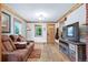 Cozy living room featuring hardwood floors, natural wood trim, and a rustic entertainment center at 4716 Broadway, Denver, CO 80216