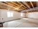Unfinished basement with painted walls, exposed ceiling, and two bright windows at 56459 E 23Rd Pl, Strasburg, CO 80136
