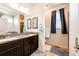 Bathroom with dual sinks, granite countertops, a decorative mirror and updated fixtures at 56459 E 23Rd Pl, Strasburg, CO 80136