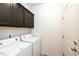 Clean laundry room with washer, dryer and overhead cabinets for additional storage at 56459 E 23Rd Pl, Strasburg, CO 80136