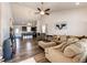 Bright living room with wood floors, vaulted ceiling, and an open layout to kitchen and dining areas at 56459 E 23Rd Pl, Strasburg, CO 80136