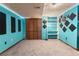Finished basement with bright blue walls, carpet, shelving, and decor perfect as a studio or rec room at 3280 S Ouray Way, Aurora, CO 80013