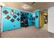 Finished basement with bright blue walls, carpet, built in desk and shelving perfect as a studio or rec room at 3280 S Ouray Way, Aurora, CO 80013