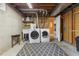 Functional laundry room with washer, dryer, utility sink, and patterned rug on a concrete floor at 3280 S Ouray Way, Aurora, CO 80013