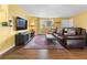 Cozy living room featuring a large brown leather sofa, area rug, and a bright window at 3280 S Ouray Way, Aurora, CO 80013