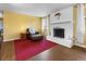 Cozy living room featuring a white brick fireplace, large windows, and hardwood flooring at 3280 S Ouray Way, Aurora, CO 80013