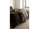 A comfortable bedroom featuring a bed with brown linens and a grey throw at 1133 14Th St # 1850, Denver, CO 80202