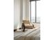 Sunlit bedroom with a unique woven chair and book by a large window, offering city views at 1133 14Th St # 1850, Denver, CO 80202