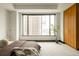 Bright bedroom with a brown bed, large window, and a wooden wardrobe, offering city views at 1133 14Th St # 1850, Denver, CO 80202