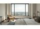 Bright bedroom with a woven chair next to a large window, overlooking the cityscape at 1133 14Th St # 1850, Denver, CO 80202