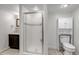 Bathroom featuring a shower with glass door, toilet and a dark vanity at 3604 Collins St, Castle Rock, CO 80108
