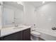 White bathroom featuring a vanity, mirror, toilet, and shower-tub combination at 1311 Rock Cliff Ave, Erie, CO 80516