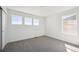 Sunlit bedroom with large windows, gray carpeting, and a closet for storage at 1311 Rock Cliff Ave, Erie, CO 80516