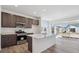 Kitchen with stainless appliances, quartz counters, large island and sliding doors to patio at 1311 Rock Cliff Ave, Erie, CO 80516