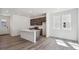Open kitchen featuring an island with a sink, modern appliances, and light wood flooring at 1311 Rock Cliff Ave, Erie, CO 80516