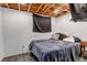 The main bedroom has an exposed wooden ceiling and a queen-sized bed with black sheets at 2700 W 91St Ave, Denver, CO 80260
