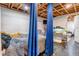 Cozy basement bedroom with exposed wooden ceiling, privacy curtain, and painted walls at 2700 W 91St Ave, Denver, CO 80260