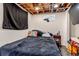View of the bedroom with the bed covered with a dark gray bedspread and a black privacy curtain at 2700 W 91St Ave, Denver, CO 80260