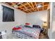 Cozy basement bedroom with exposed wood ceiling, painted walls, and carpeted floors at 2700 W 91St Ave, Denver, CO 80260