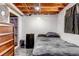 Compact basement room with a bed, minifridge, and basic furnishings, offering potential as a spare bedroom at 2700 W 91St Ave, Denver, CO 80260
