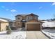 Two-story house with a brown and beige exterior, attached garage, and snow-covered front yard at 1018 Mcmurdo Cir, Castle Rock, CO 80108