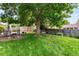 Spacious backyard with a mature tree, patio set, and well-maintained lawn ideal for outdoor gatherings at 915 Mercury Cir, Littleton, CO 80124