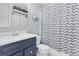 The bathroom features a stylish vanity with a sink, toilet, and a shower with a patterned curtain at 915 Mercury Cir, Littleton, CO 80124