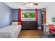 Charming bedroom with hardwood floors, ceiling fan, and a large window showcasing the outdoor greenery at 915 Mercury Cir, Littleton, CO 80124