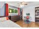 Bright bedroom with hardwood floors, ceiling fan, and a large window with natural light at 915 Mercury Cir, Littleton, CO 80124