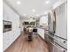 Bright kitchen features stainless appliances, custom white cabinets and beautiful wood floors at 915 Mercury Cir, Littleton, CO 80124