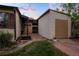 Cozy backyard featuring a detached garage, brick pavers, and lush green grass at 2840 S Yates St, Denver, CO 80236