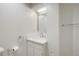 Bright half bathroom featuring a white vanity with chrome fixtures and a modern square mirror at 2840 S Yates St, Denver, CO 80236