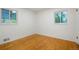 Bright bedroom with hardwood floors, two windows for natural light and neutral paint at 2840 S Yates St, Denver, CO 80236